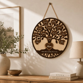 Wooden family tree wall decor hanging on a wall with books and a lamp in the background.
