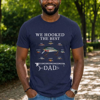 Man wearing a navy blue t-shirt with a fishing-themed design outdoors.
