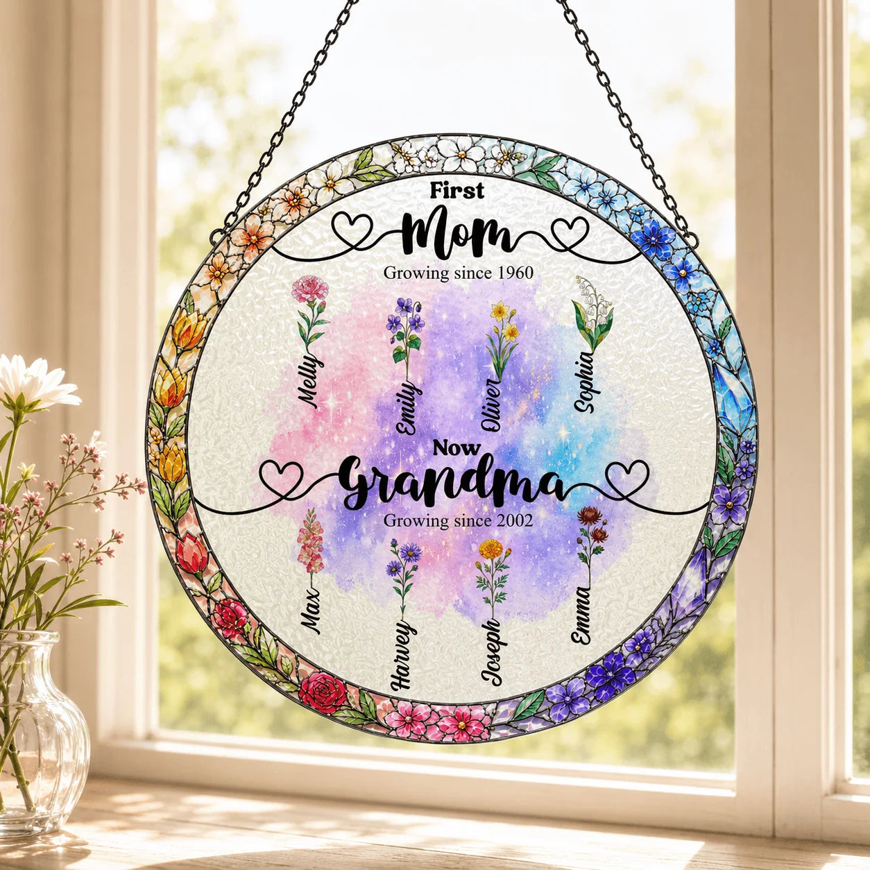 Round floral-themed decorative piece with names on a window sill.