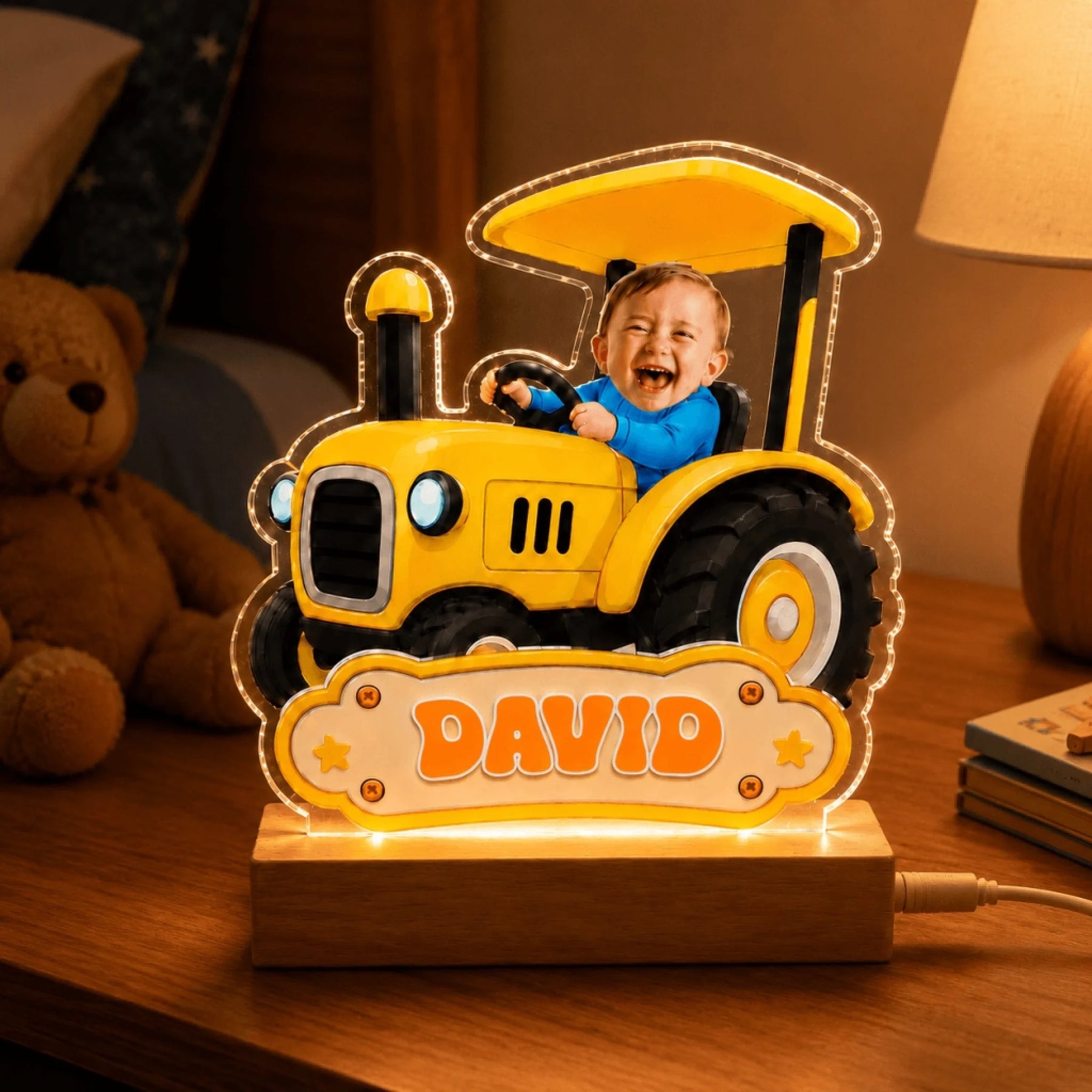 Customized tractor nursery lamp featuring photo of baby David, glowing on a bedside table next to a teddy bear.