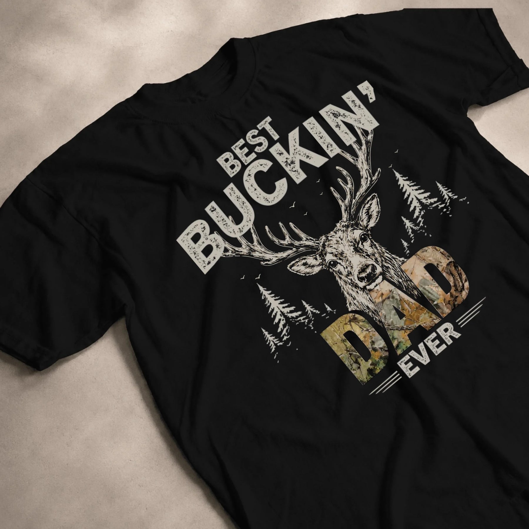 Black cotton t-shirt featuring a deer head, forest landscape, and Best Buckin Dad Ever text for a stylish hunting fan.