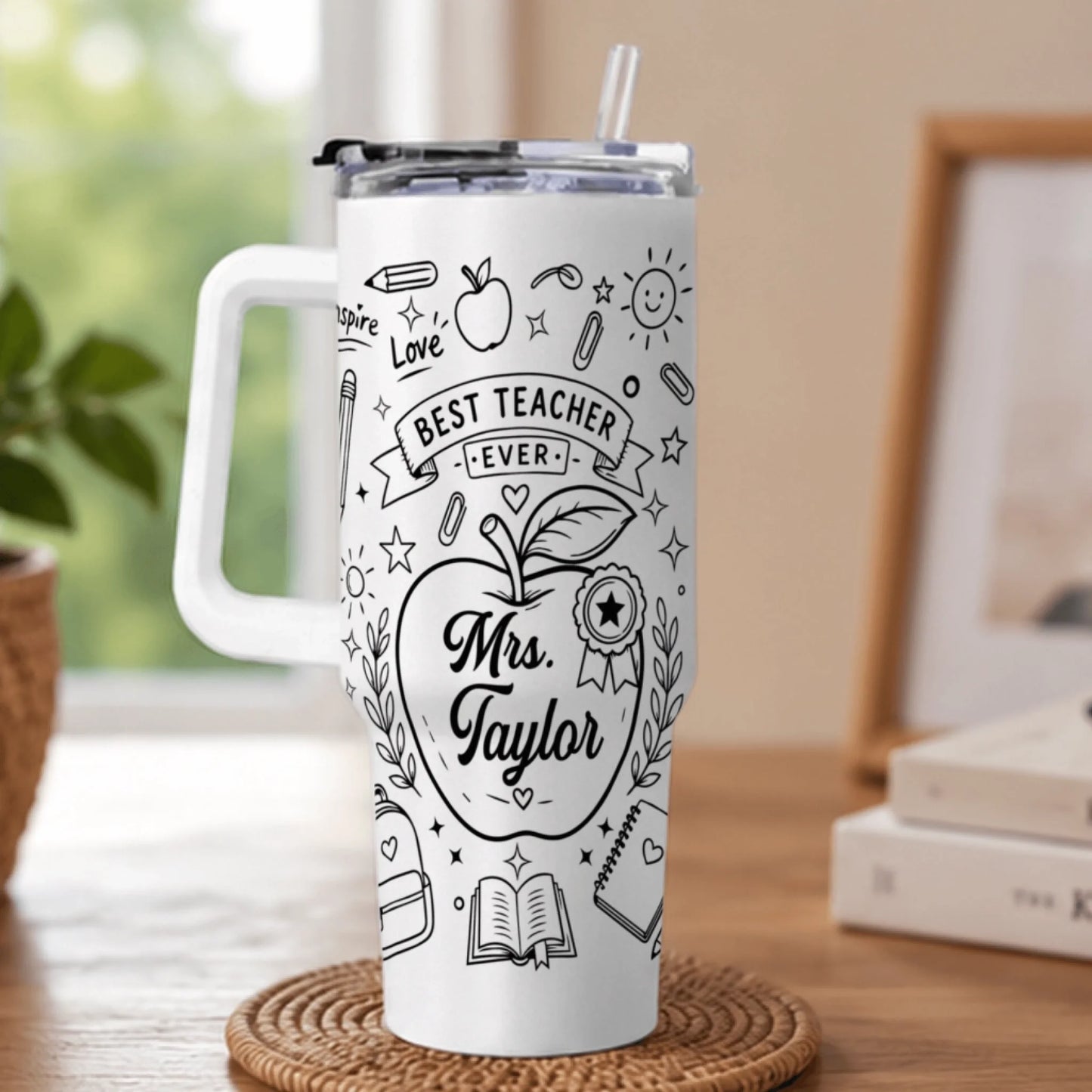 White travel tumbler with handle, decorated with black school supply doodles and personalized Mrs. Taylor name.