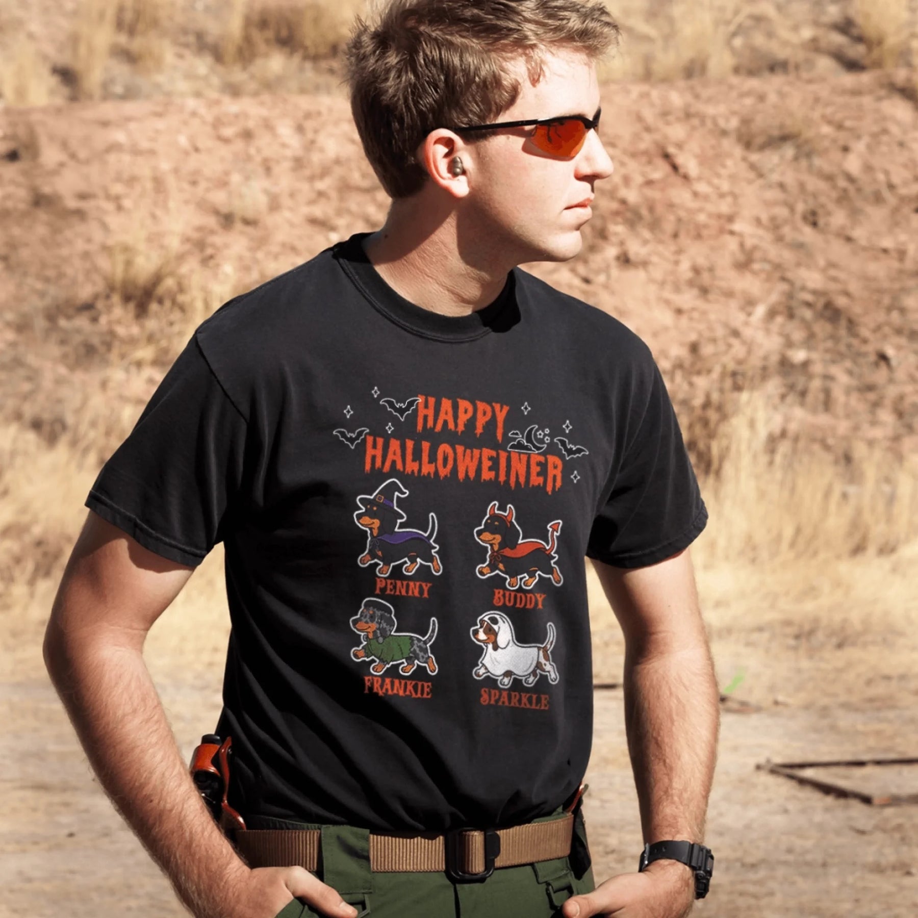 Black custom Halloween t-shirt featuring four illustrated dachshund dogs in costumes with their names printed below.