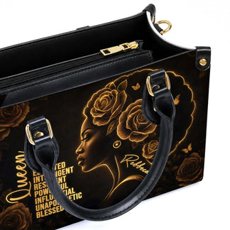 Close up of a black queen tote bag featuring gold rose design and interior zipper pocket for organized everyday use.