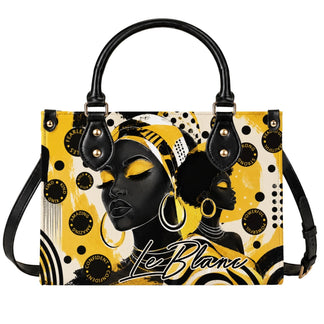 A stylish handbag featuring artistic illustrations of Black women with yellow and black abstract patterns and affirmations.