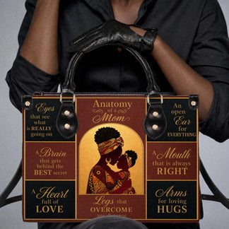 A woman holding a stylish handbag with Anatomy of a Mom artwork depicting a mother and child silhouette.