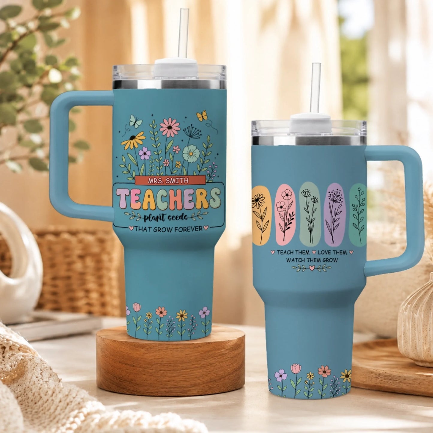 Light blue insulated tumbler for teachers featuring colorful floral garden design and custom name, on wooden stand.