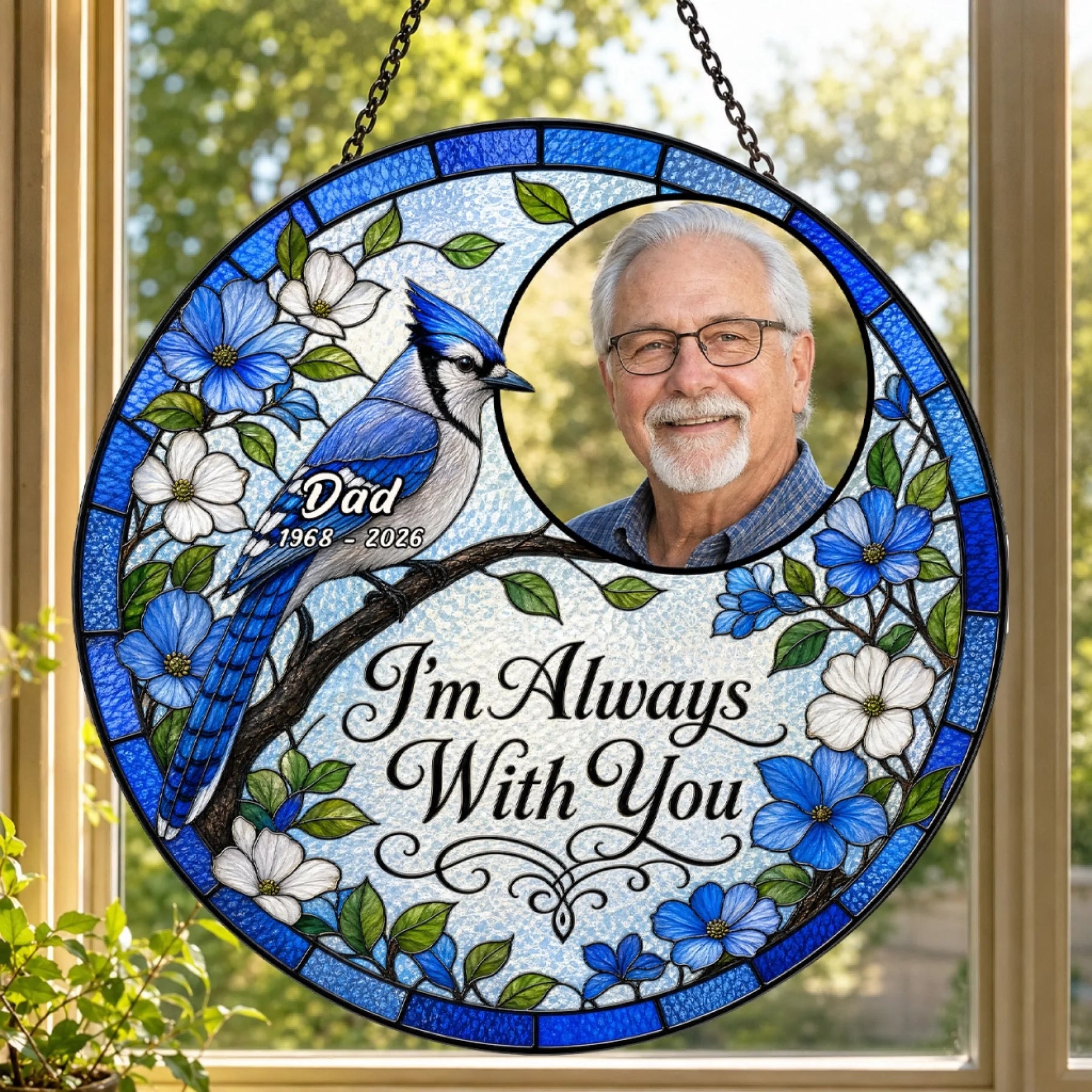 Round stained glass memorial ornament featuring a blue jay, dogwood flowers, photo of a man, and 'I'm Always With You'.