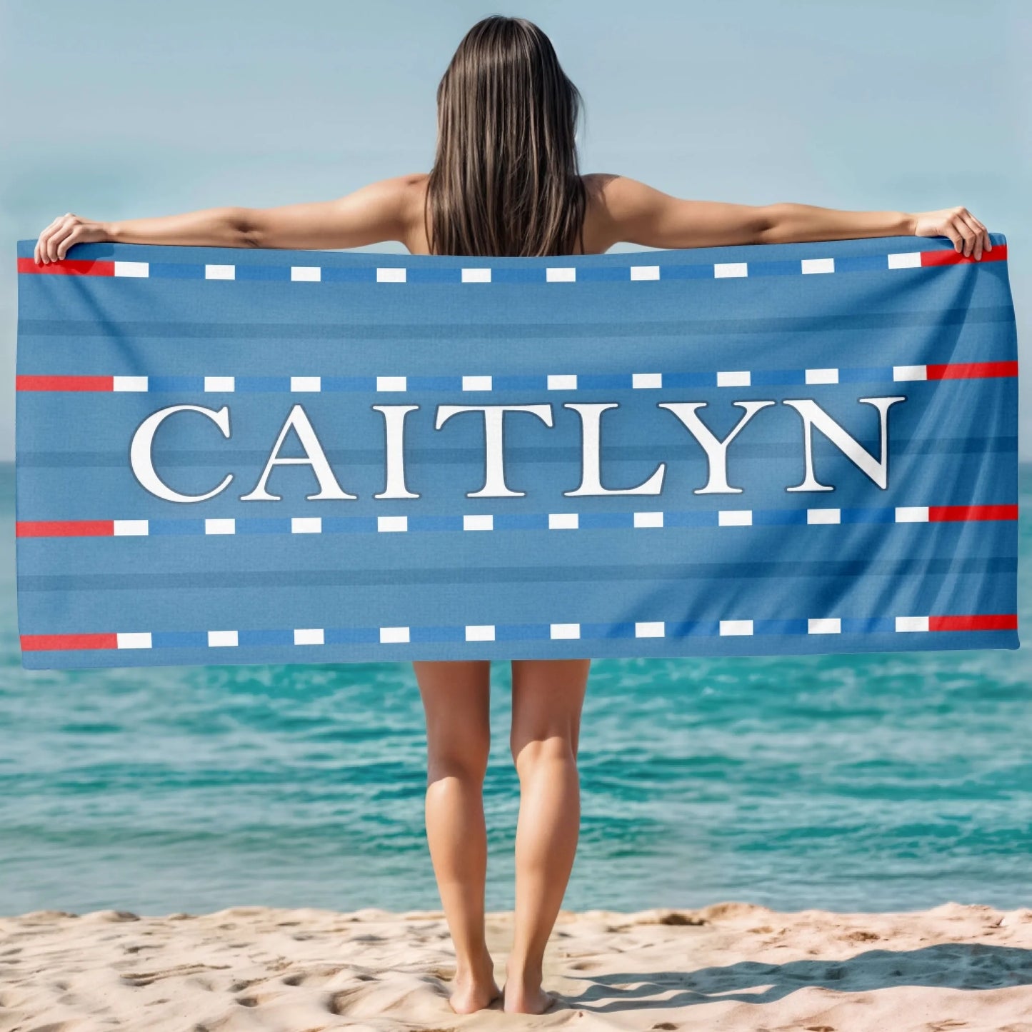 Custom swimming theme beach towel with a lane marker design and the name Caitlyn in elegant white capital letters.
