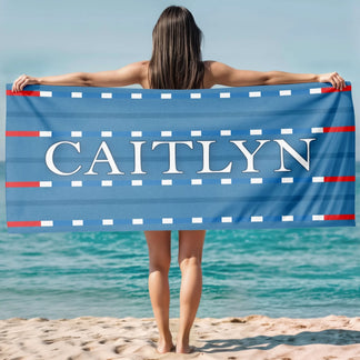 Custom swimming theme beach towel with a lane marker design and the name Caitlyn in elegant white capital letters.