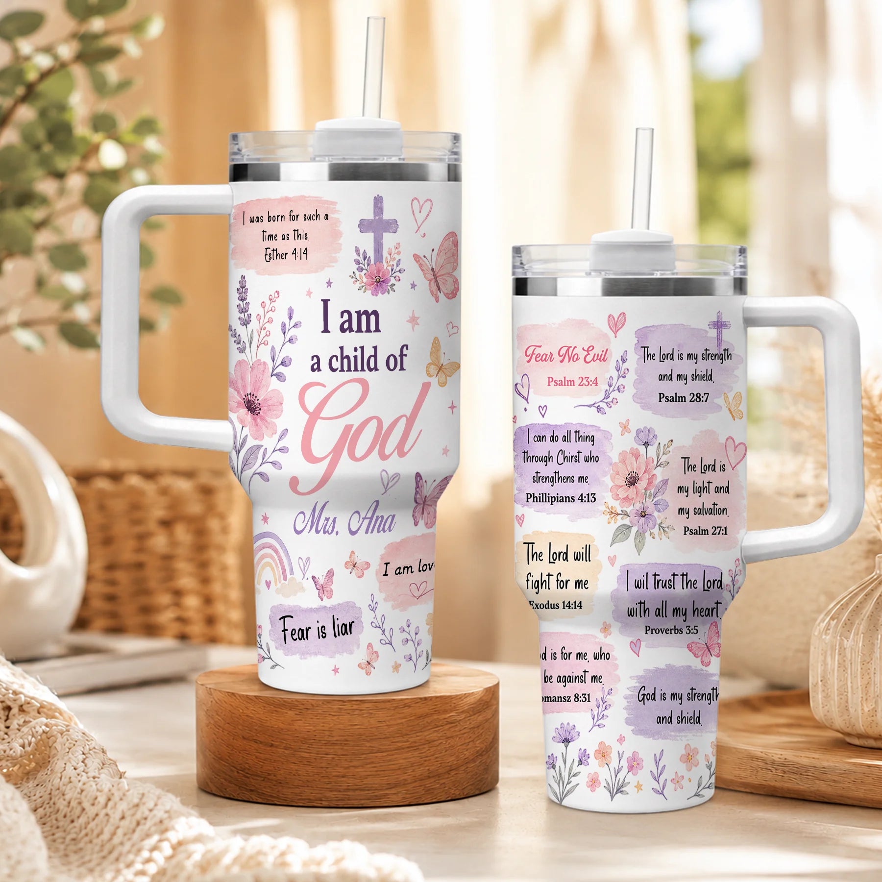 Set of two Christian-themed stainless steel tumblers with lids and straws, featuring floral prints, butterflies, and faith quotes.