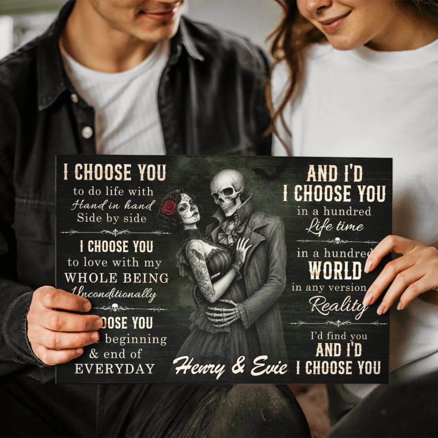 Couple holding a custom skeleton couple wall art canvas with the romantic quote I choose you and custom names Henry and Evie.