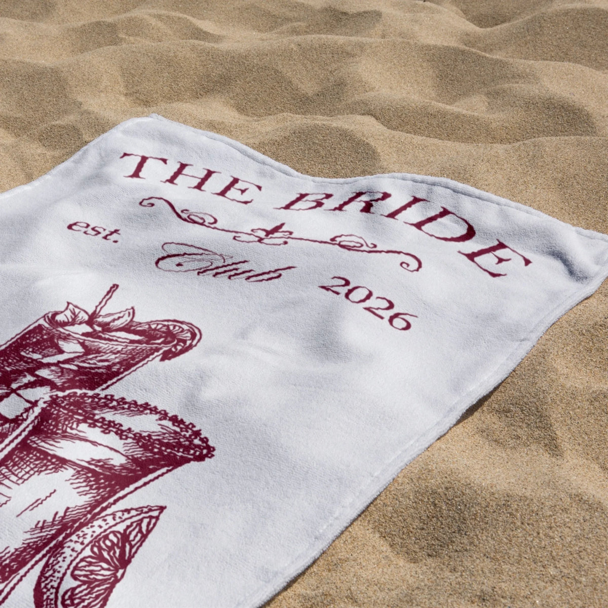 Personalized bridal beach towel with cocktail illustrations and custom bachelorette party text for a bride.