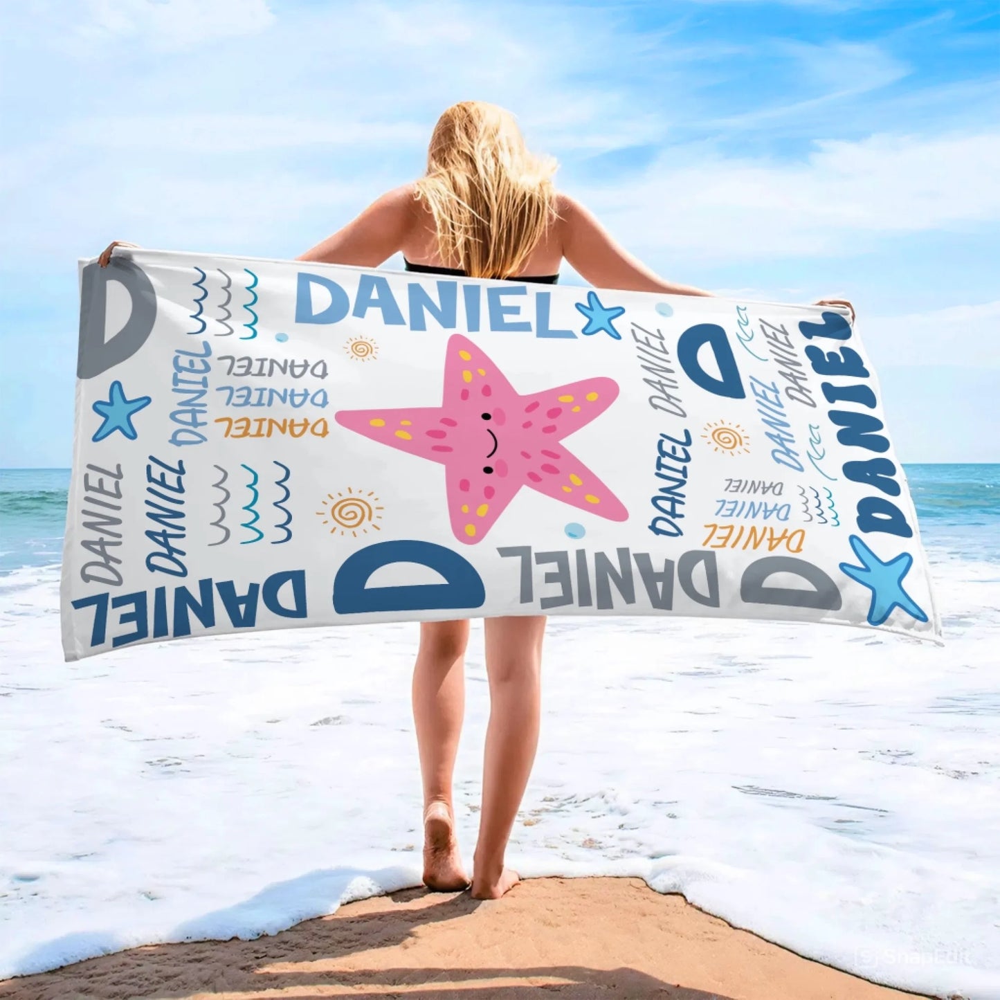 Personalized beach towel with a starfish print and Daniel text design, perfect for beach days or summer vacations.