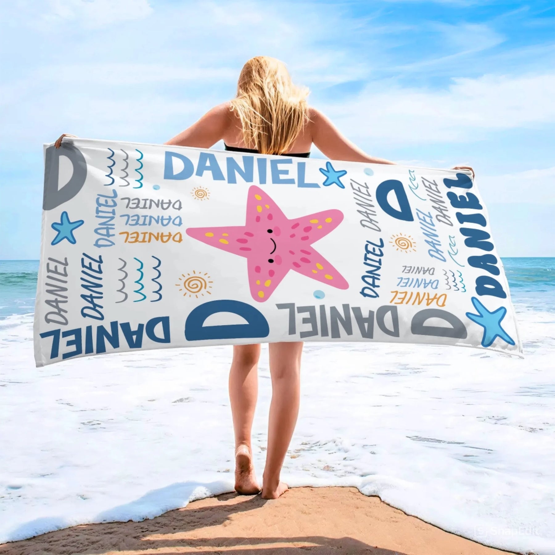 Personalized beach towel with a starfish print and Daniel text design, perfect for beach days or summer vacations.