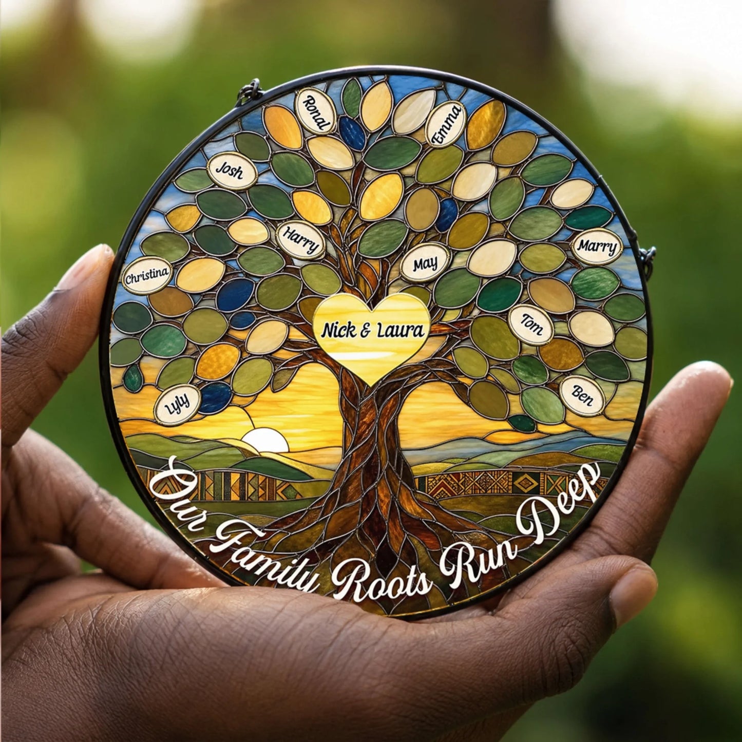 Hand holding a personalized stained glass family tree suncatcher with custom engraved names and a heart center piece.