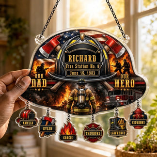 Hand holding a personalized firefighter suncatcher with hanging family name charms for a firefighter dad memorial.