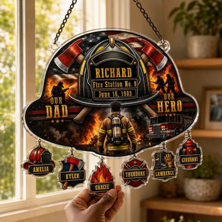 Personalized firefighter suncatcher hanging in a window with family names displayed on individual custom charms.
