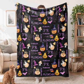 Person holding a custom black fleece throw blanket with Florian name print and spooky Halloween decorations.
