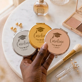 Hand holding three personalized compact mirrors in silver gold and rose gold colors for graduation gift ideas 2026.