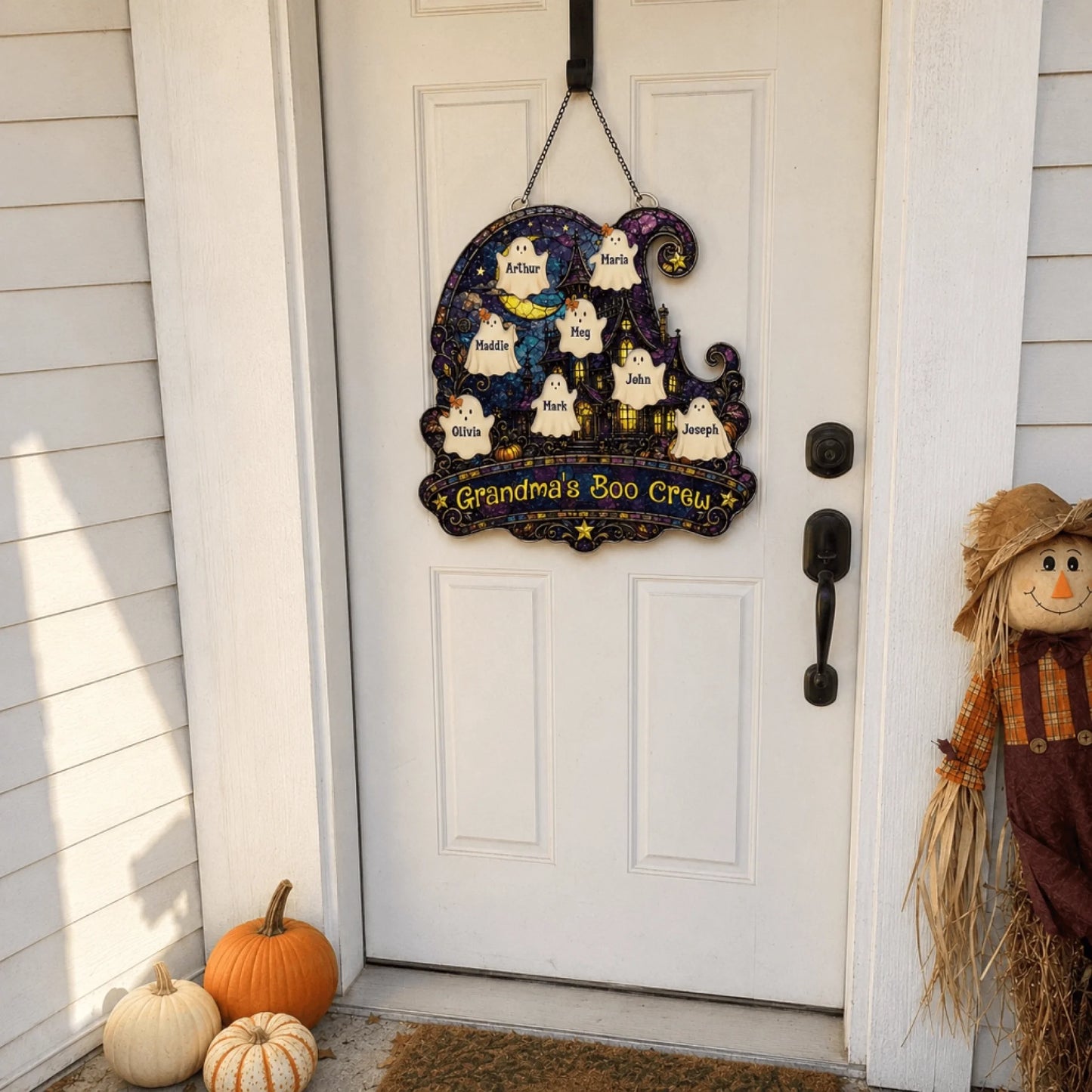 Custom Grandma's Boo Crew ghost acrylic door sign hanging on a white front door with pumpkins for Halloween.