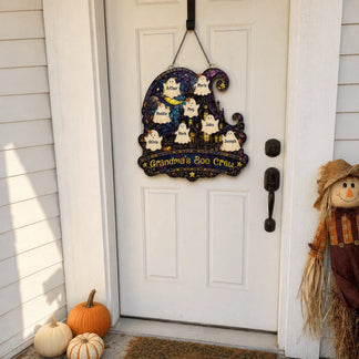 Custom Grandma's Boo Crew ghost acrylic door sign hanging on a white front door with pumpkins for Halloween.