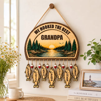 Decorative personalized wooden sign for grandpa featuring a scenic lake illustration and hanging fish ornaments with names.