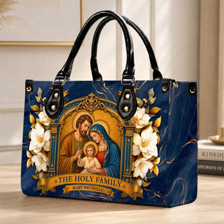 A stylish PU leather handbag with The Holy Family artwork placed on a table in a home setting.