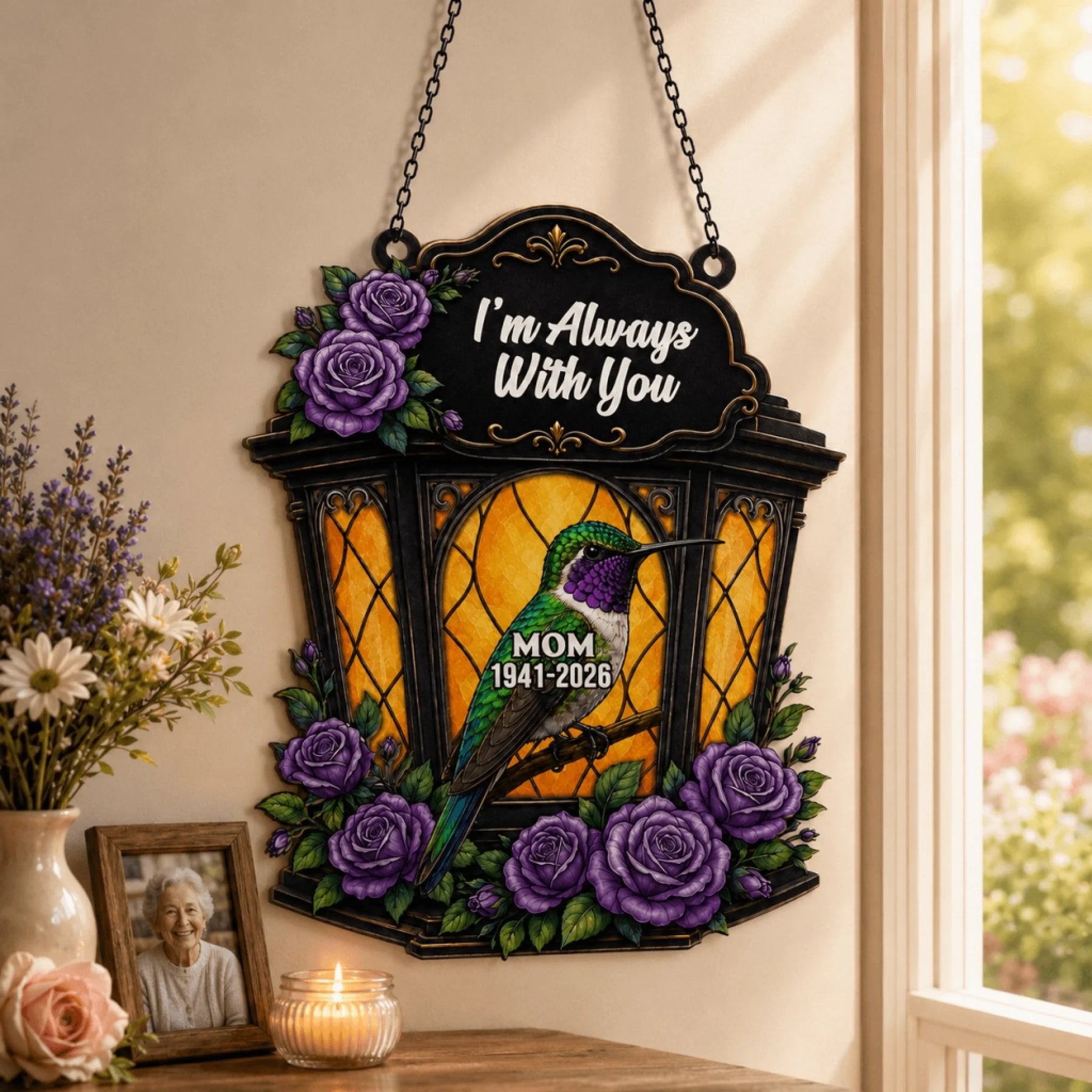 Personalized memorial hummingbird suncatcher with purple roses and Mom 1941 2026 text displayed next to a photo frame.