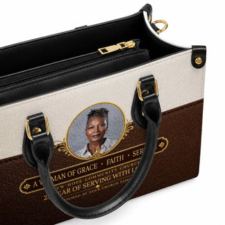 Close up of a personalized leather handbag featuring a custom portrait photo and meaningful church anniversary quote.