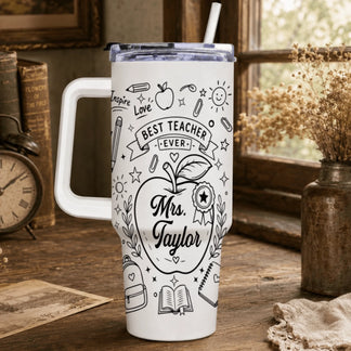 Custom white teacher tumbler with Best Teacher Ever graphic and apple illustration, sitting on a rustic wooden table.