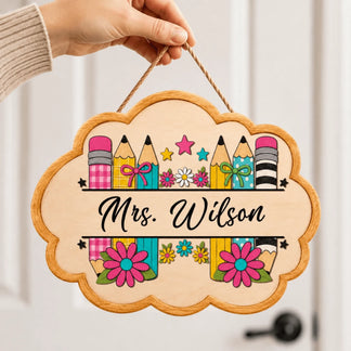 Handheld custom classroom door hanging sign for Mrs Wilson with pencil motifs and colorful floral accents.