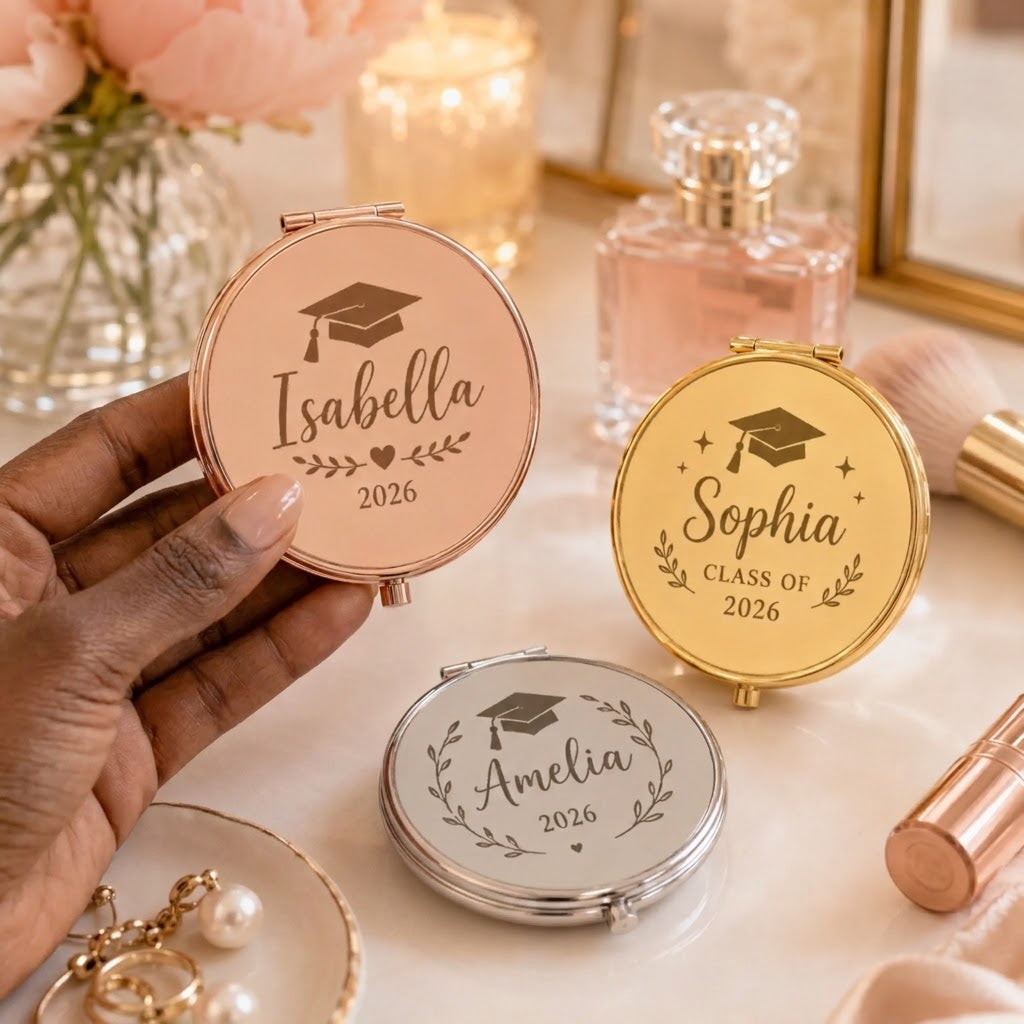Close up of a hand holding a rose gold personalized graduation compact mirror with custom name and year 2026.