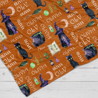 Personalized witch themed fleece throw blanket for Halloween featuring black cats and custom name text on orange.