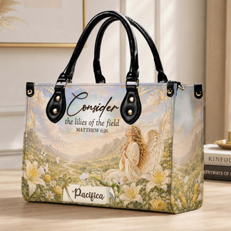 This custom name handbag displays a serene angel surrounded by lilies and butterflies with the inspirational Matthew 6 26 Bible verse