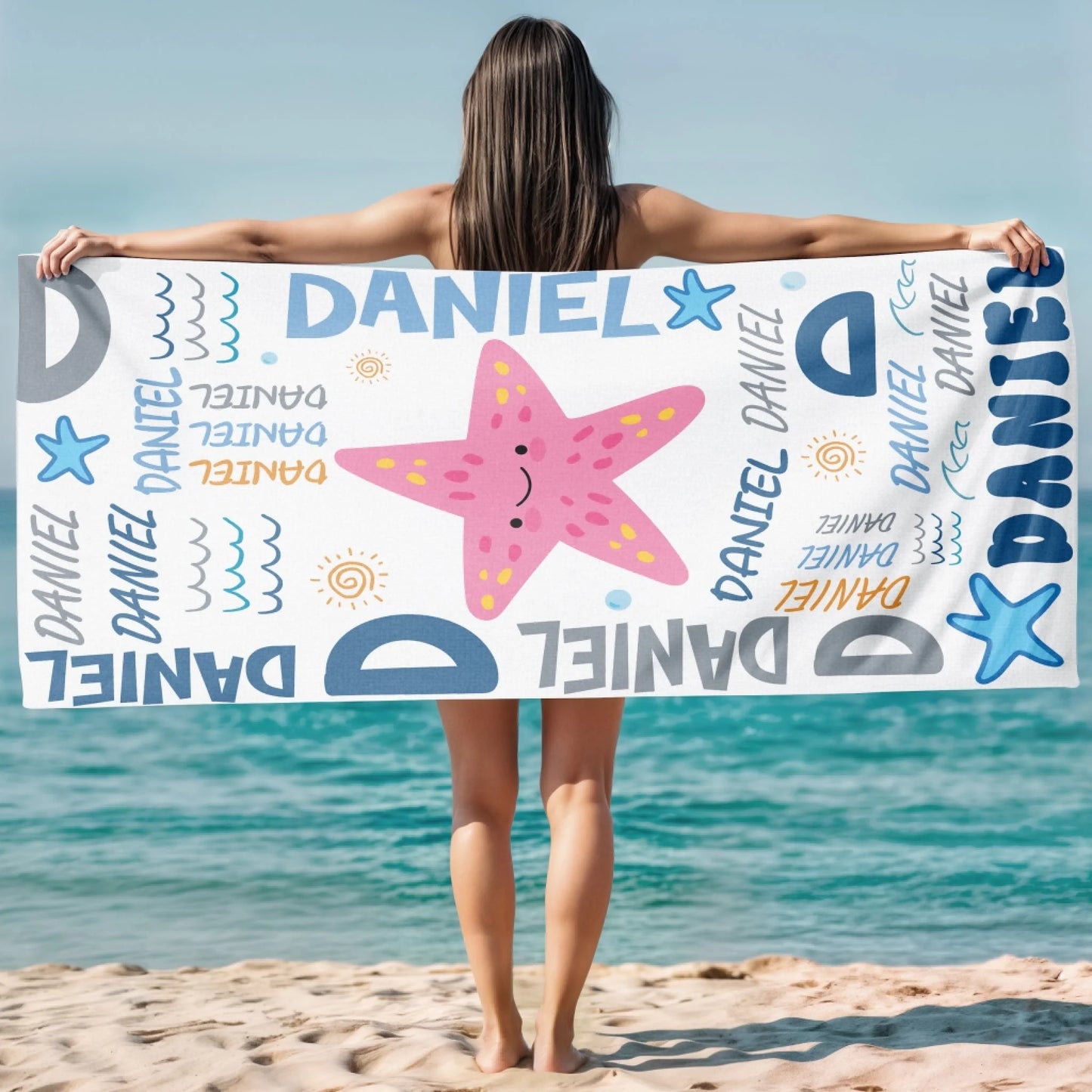 A personalized beach towel design showing a happy pink starfish, stars, and waves with the name Daniel repeatedly.