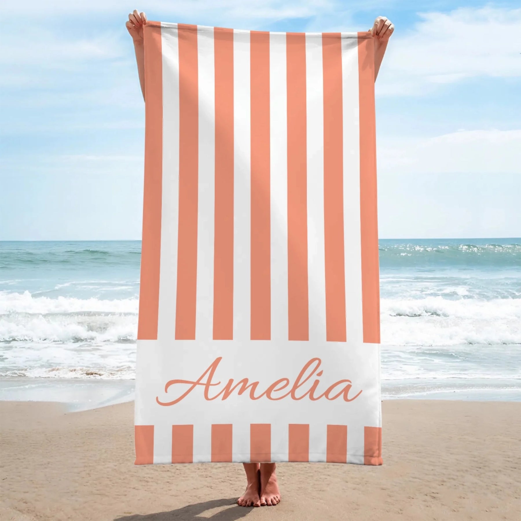 Personalized peach and white vertical striped beach towel with the name Amelia printed for a unique beach accessory.
