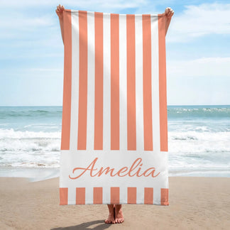 Personalized peach and white vertical striped beach towel with the name Amelia printed for a unique beach accessory.