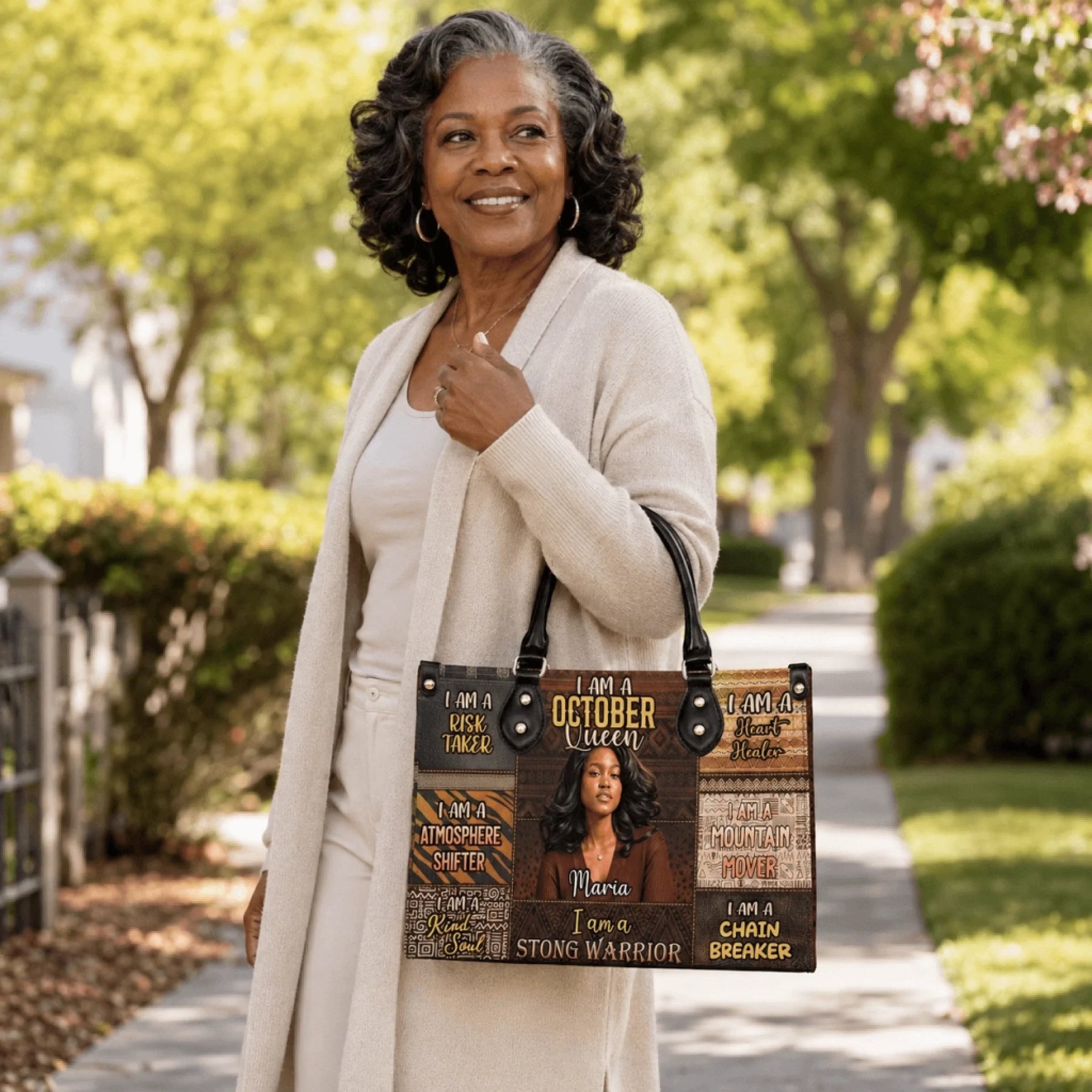 A woman holding a personalized October Queen handbag with a custom name and motivational text for a birthday gift.