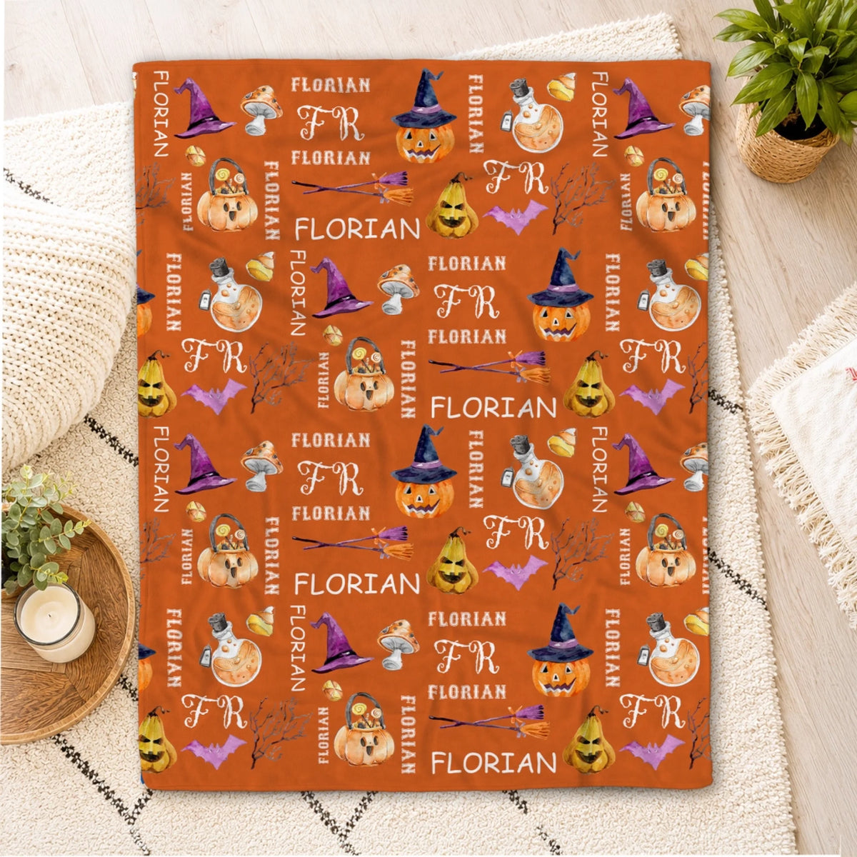 Custom orange Halloween fleece blanket patterned with pumpkins, witch hats, and the name Florian for a festive gift.
