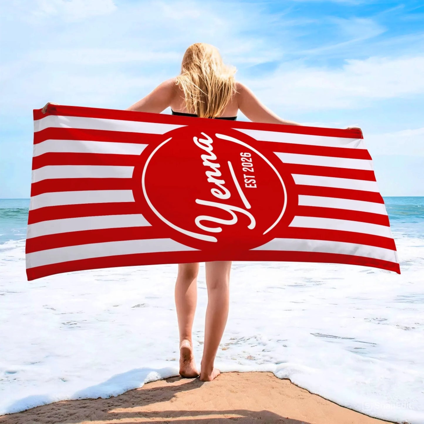 Personalized beach towel featuring red and white stripes with a custom name and est 2026 printed on the center circle.