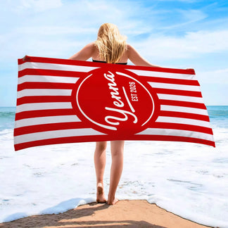 Personalized beach towel featuring red and white stripes with a custom name and est 2026 printed on the center circle.