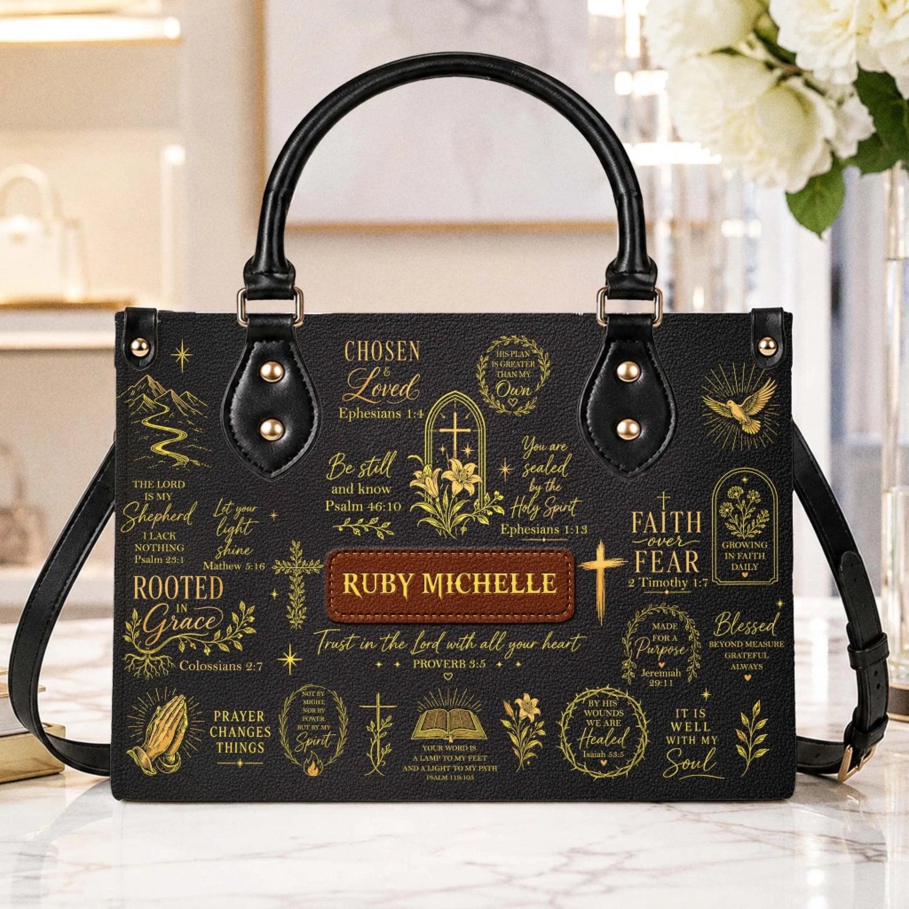 A stylish black Christian-themed handbag with gold inspirational Bible verses and a custom name tag for a meaningful gift.