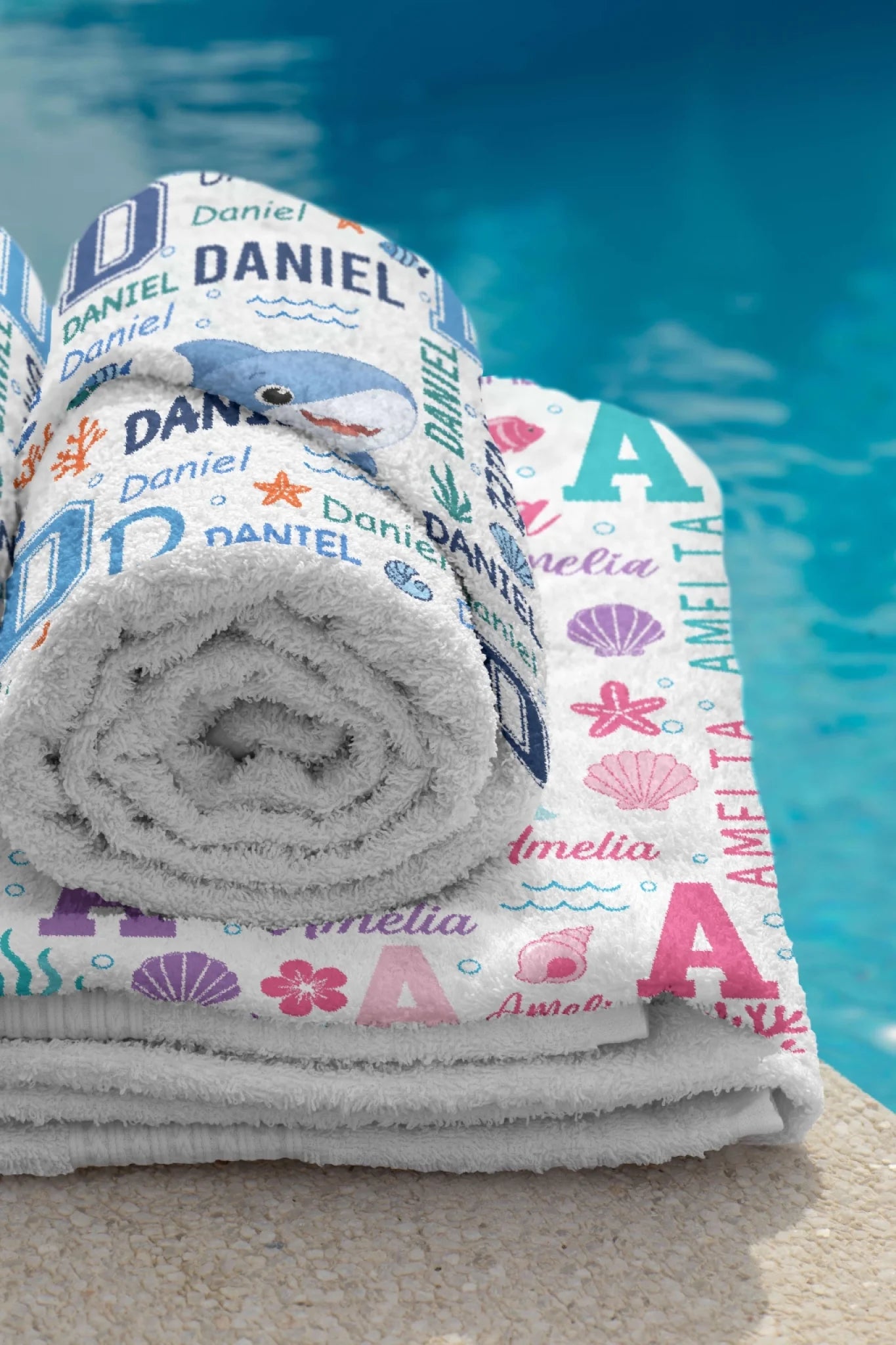 Rolled personalized beach towels with shark and mermaid designs, custom gifts for kids summer pool and beach days.