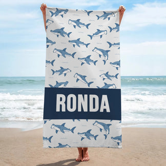 Personalized shark pattern beach towel with the name Ronda printed on a navy stripe for summer beach vacations.