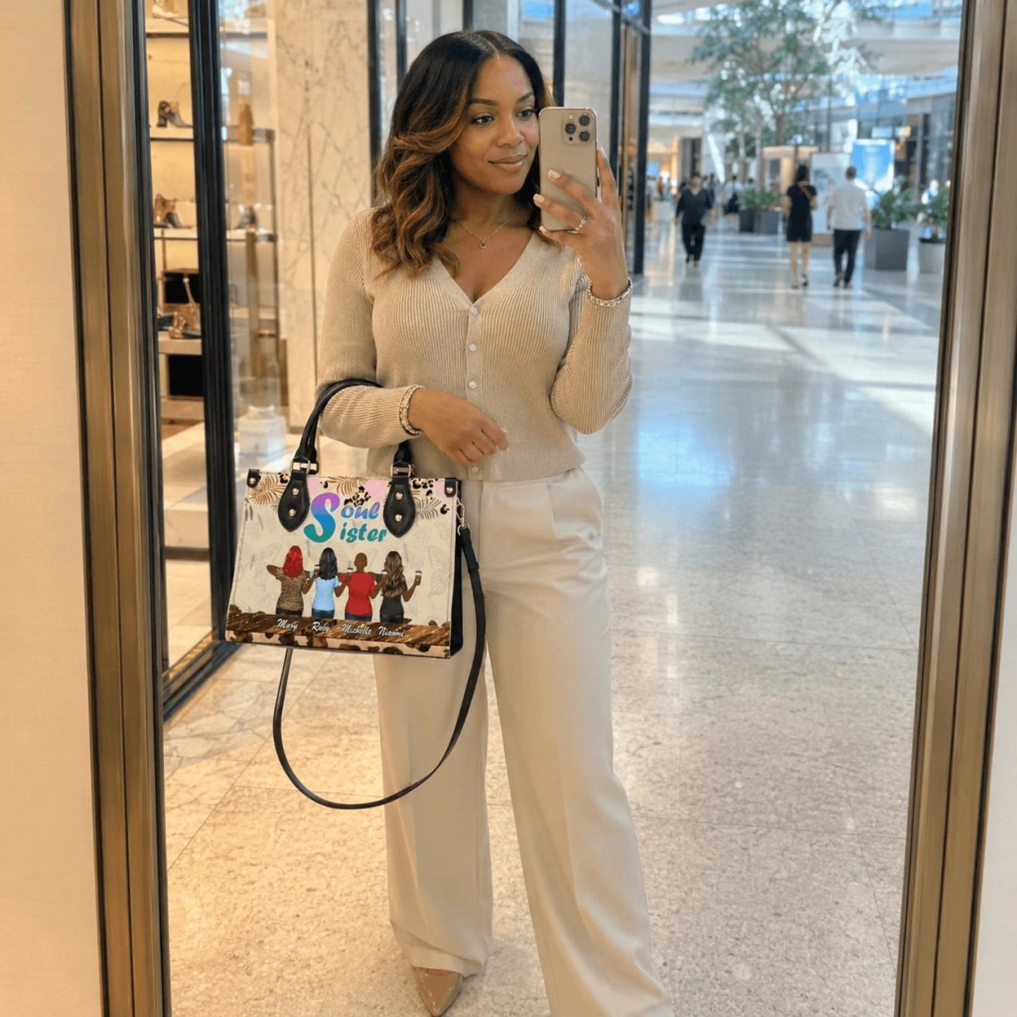 Woman posing in a store mirror holding a personalized Soul Sister handbag featuring custom names and friend artwork.