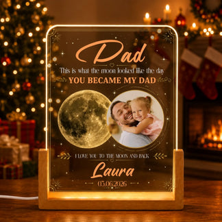 Personalized light-up sign with a photo of a father and child, moon graphic, and text in a festive setting.