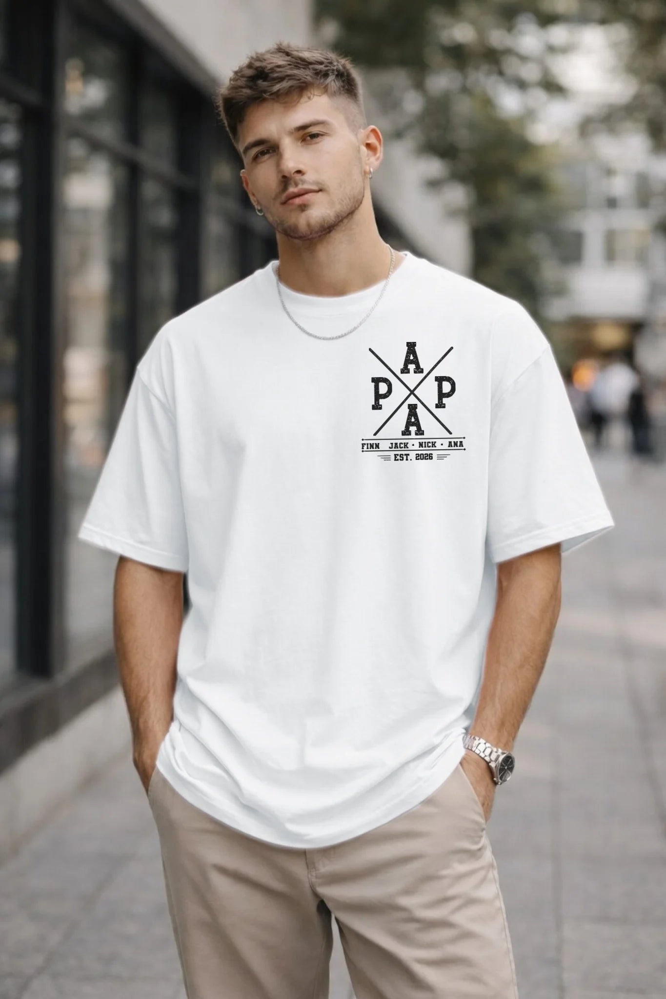 Man wearing a white t-shirt with a logo on a city street