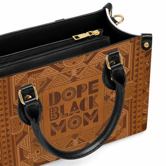 Close up view of the Dope Black Mom leather handbag showing detailed tribal patterns and black handle hardware.
