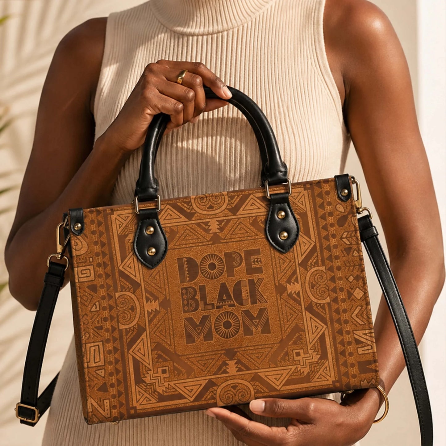 A stylish brown PU leather handbag featuring a bold Dope Black Mom graphic design with intricate tribal patterns.
